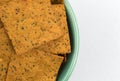 Thin gourmet snack crackers in a green bowl