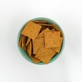 Thin gourmet snack crackers in a green bowl