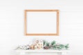 Thin light wood frame on mantelpiece with spruce branches Royalty Free Stock Photo