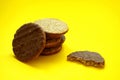 Oatmeal cookies or healthy cereal oat crackers with chocolate. Crispy anzac biscuit cookie with oat flakes on yellow background. Royalty Free Stock Photo