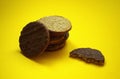 Thin oatmeal cookies or healthy cereal oat crackers with chocolate. Crispy anzac biscuit cookie with oat flakes on yellow backgrou Royalty Free Stock Photo