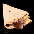 a thin pancake with chocolate is  on a black background, Pancakes with chocolate syrup Royalty Free Stock Photo