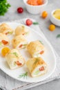 Thin pancake rolls or crepes rolls with smoked salmon, cream cheese, cucumber and dill on a gray concrete background. Royalty Free Stock Photo