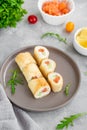 Thin pancake rolls or crepes rolls with smoked salmon, cream cheese, cucumber and dill on a gray concrete background. Royalty Free Stock Photo