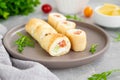 Thin pancake rolls or crepes rolls with smoked salmon, cream cheese, cucumber and dill on a gray concrete background. Royalty Free Stock Photo