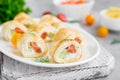 Thin pancake rolls or crepes rolls with smoked salmon, cream cheese, cucumber and dill on a gray concrete background. Royalty Free Stock Photo