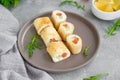 Thin pancake rolls or crepes rolls with smoked salmon, cream cheese, cucumber and dill on a gray concrete background. Royalty Free Stock Photo