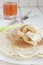 Thin pancakes, apricot jam in a glass