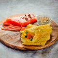 Thin pancakes with red fish on plate, top view.Crepes with filet salmon and cheese, red fish and green avocado on white plate over