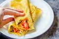 Thin pancakes with red fish on plate, top view.Crepes with filet salmon and cheese, red fish and green avocado on white plate over