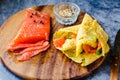 Thin pancakes with red fish on plate, top view.Crepes with filet salmon and cheese, red fish and green avocado on white plate over