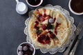 Thin pancakes with wheat flour, eggs and kefir, served with berries, jam and cup of cofee on gray table. Top view Royalty Free Stock Photo