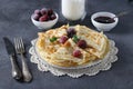 Thin pancakes with wheat flour, eggs and kefir, served with berries, jam and a glass of milk on gray table Royalty Free Stock Photo