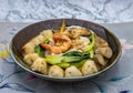 Thin rice noodles soup with mussels, shrimp, meatball, mushroom and vegetable serving in ceramic bowl Royalty Free Stock Photo