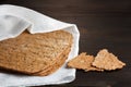 Thin rye flour bread with bran and oat flakes on a white kitchen towel on table Royalty Free Stock Photo