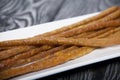 Thin sausages for beer. On a rectangular plate. Background from pine boards. Close-up Royalty Free Stock Photo
