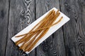 Thin sausages for beer. On a rectangular plate. Background from pine boards. Close-up Royalty Free Stock Photo