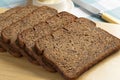 Thin slices of fresh baked brown linseed bread close up on a cutting board Royalty Free Stock Photo