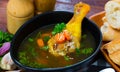 Thin soup with chicken leg in black bowl Royalty Free Stock Photo