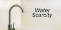 thin stream of water flows of the faucet with water scarcity text