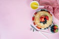 Thin traditional Russian pancakes on a trendy pink background with berries and honey. Top view, copy space Royalty Free Stock Photo