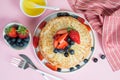 Thin traditional Russian pancakes on a trendy pink background with berries and honey. H orizontal p hoto, c lo s e- up Royalty Free Stock Photo