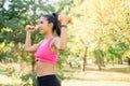 Thin woman trains biceps with orange weights Royalty Free Stock Photo