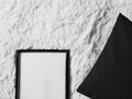 Thin wooden frame with blank copyspace as poster photo print mockup, black cushion pillow and fluffy white blanket, flat Royalty Free Stock Photo