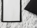 Thin wooden frame with blank copyspace as poster photo print mockup, black cushion pillow and fluffy white blanket, flat Royalty Free Stock Photo