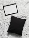 Thin wooden frame with blank copyspace as poster photo print mockup, black cushion pillow and fluffy white blanket, flat Royalty Free Stock Photo