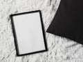 Thin wooden frame with blank copyspace as poster photo print mockup, black cushion pillow and fluffy white blanket, flat Royalty Free Stock Photo