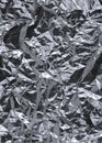 Thin wrinkled sheet of crushed tin aluminum silver foil background with shiny crumpled surface for texture Royalty Free Stock Photo