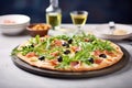 thincrust pizza with olives and arugula on a stone backdrop Royalty Free Stock Photo