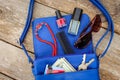 Things from open lady purse. Cosmetics, money and women`s accessories fell out of blue handbag. Royalty Free Stock Photo