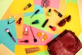 Things from open lady purse. Cosmetics and women`s accessories fell out of red handbag on colourful background. Royalty Free Stock Photo