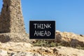 Think ahead symbol. Concept words Think ahead on beautiful black chalk blackboard on a beautiful beach stone background. Business