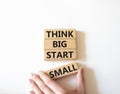 Think big start small symbol. Concept words Think big start small on wooden blocks. Beautiful white background. Businessman hand. Royalty Free Stock Photo