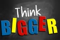 Think bigger conceptual words on blackboard Royalty Free Stock Photo