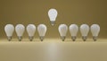 Think different concept One floating glowing idea light bulb standing out from dim unlit bulbs on yellow pastel color wall Royalty Free Stock Photo