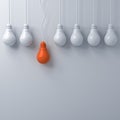 Think different concept , One hanging orange light bulb standing out from the dim unlit white light bulbs on white wall background