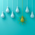 One hanging yellow idea light bulb standing out from white unlit bulbs on blue green pastel color background Royalty Free Stock Photo