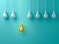 Think different concept One hanging yellow idea light bulb standing out from white unlit bulbs on blue green pastel
