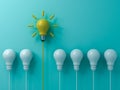Think different concept One yellow idea light bulb standing out from the white unlit bulbs on blue green pastel color background Royalty Free Stock Photo