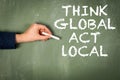 Think global act local. Text on a green chalkboard background Royalty Free Stock Photo