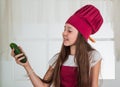 think green. chef girl in hat and apron. kid cooking food in kitchen. choosing a career. little helper with cucumber Royalty Free Stock Photo