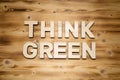 THINK GREEN words made of wooden block letters on wooden board