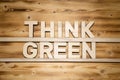 THINK GREEN words made of wooden letters on wooden board.