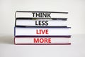 Think less live more symbol. Books with concept words Think less live more on a beautiful white background. businessman hand.