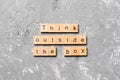 Think outside the box word written on wood block. Think outside the box text on cement table for your desing, Top view concept Royalty Free Stock Photo