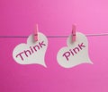 Think Pink message written on two white hearts hanging from pink pegs